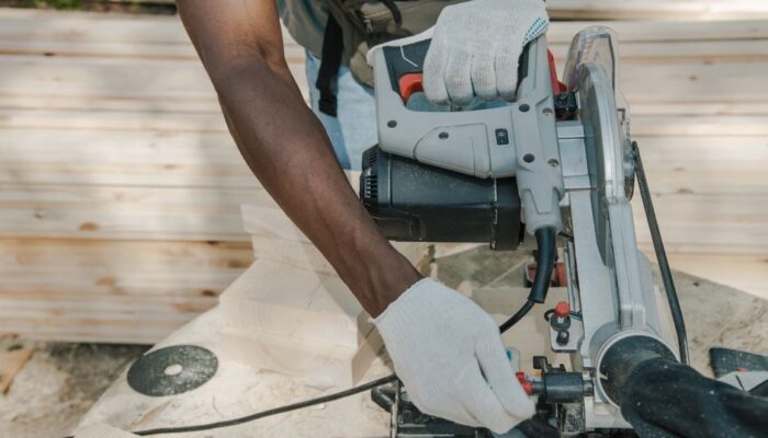 A worker uses a circular saw to cut wood outdoors, showcasing skillful woodwork techniques. - Photo by Ron Lach on Pexels