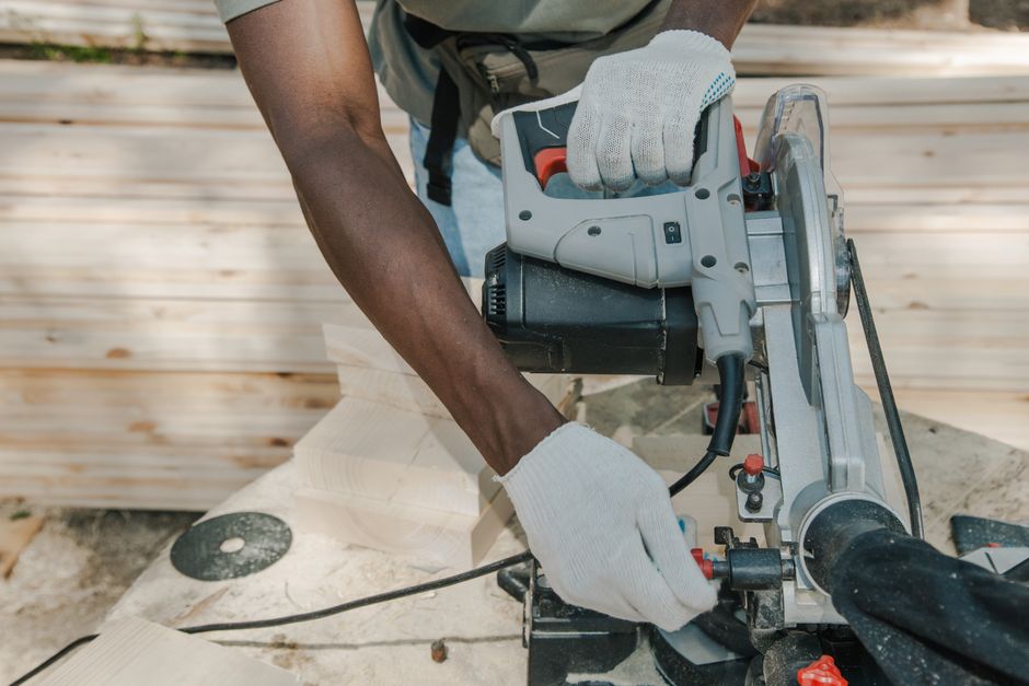 A worker uses a circular saw to cut wood outdoors, showcasing skillful woodwork techniques. - Photo by Ron Lach on Pexels