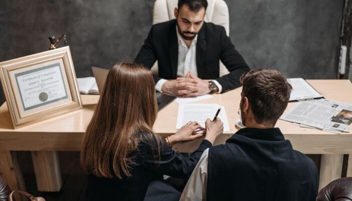 A lawyer discusses legal documents with clients in an office setting. - Photo by Pavel Danilyuk on Pexels
