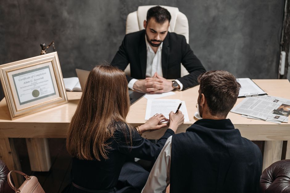 A lawyer discusses legal documents with clients in an office setting. - Photo by Pavel Danilyuk on Pexels