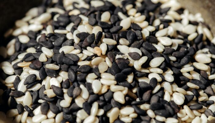 A high-resolution close-up photo of mixed black and white sesame seeds, showcasing texture and detail. - Photo by Ivan S on Pexels