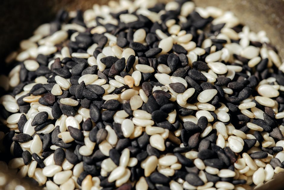 A high-resolution close-up photo of mixed black and white sesame seeds, showcasing texture and detail. - Photo by Ivan S on Pexels
