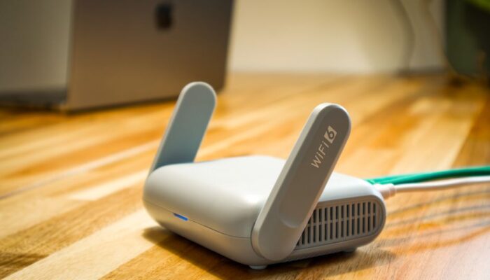 A sleek WiFi 6 router with antennas and cable on a wooden desk, perfect for modern home networks. - Photo by Pascal ???? on Pexels