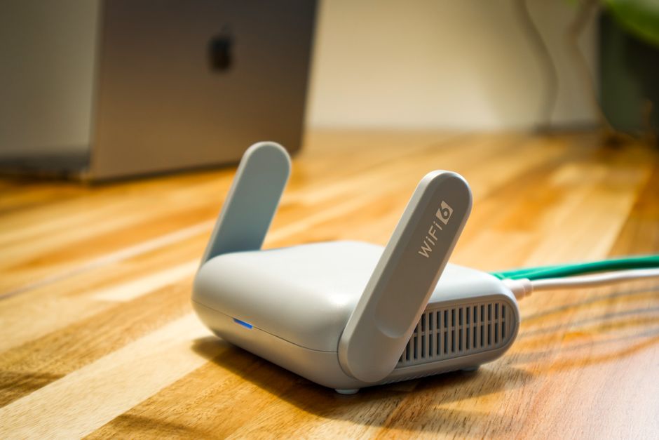 A sleek WiFi 6 router with antennas and cable on a wooden desk, perfect for modern home networks. - Photo by Pascal ???? on Pexels